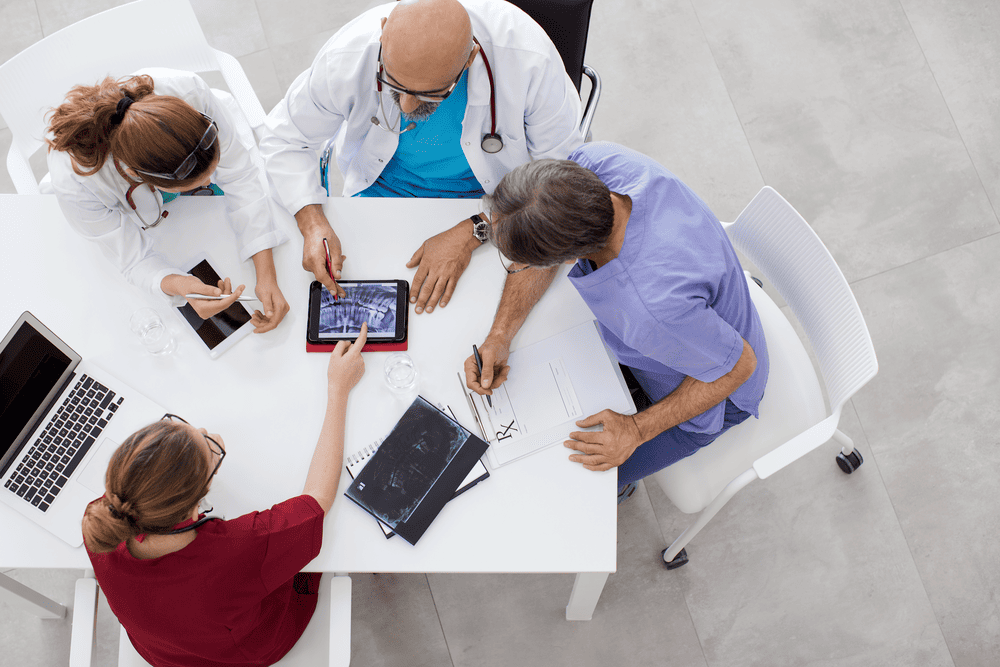 Medical professionals in discussion with city skyline background
