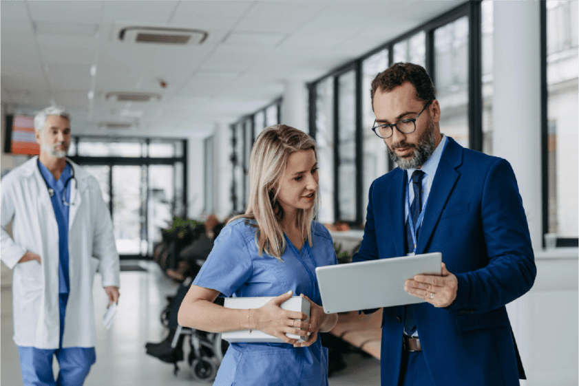 Medical professionals collaborating around a table with laptops and documents